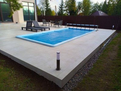 Прямоугольный бассейн с синим защитным покрытием на бетонной площадке